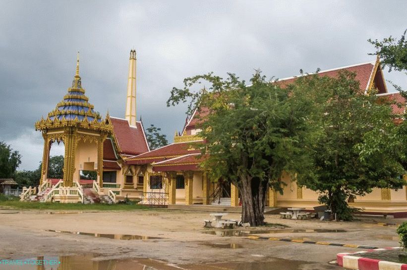 Врло тајландска фотографија: крематоријум, храм, сто испод дрвета, локве и брзински удар на земљаном путу.